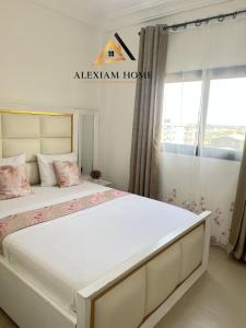 a bedroom with a large bed with pink pillows at Studio Moderne et Chic in Douala