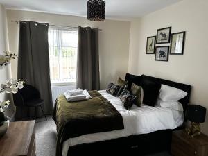 a bedroom with a bed with black and white pillows at Safari Avenue one Bedroom Apartment in Stapleford