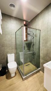 y baño con ducha de cristal y aseo. en Marrone Hotel Tsaghkadzor, en Tsaghkadzor