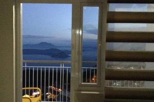 a view of the ocean from a window in a building at Blowing in the Wind - Lake View Apartments in Tagaytay