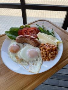 a plate of breakfast food with eggs sausage and vegetables at СвояХата in Svityazʼ