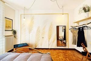 Villa Camelia32 Milano&Como في Barlassina: غرفة نوم مع سرير ومرآة على الحائط