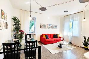 un soggiorno con divano rosso e tavolo di Villa Camelia32 Milano&Como a Barlassina