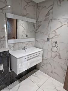 a bathroom with a white sink and a mirror at Palm lake resort Folla Monastir in Monastir