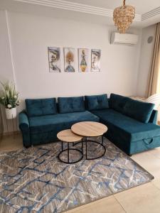 莫納斯提爾的住宿－Palm lake resort Folla Monastir，客厅配有蓝色的沙发和桌子
