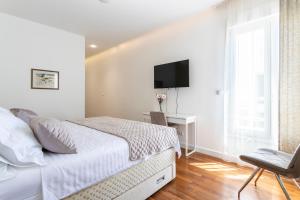 a bedroom with a bed and a tv on a wall at Apartments Blue Maris Žnjan in Split