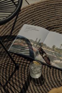 a magazine with a pair of glasses and a drink at Zaira Hotel in Skála Loutrón