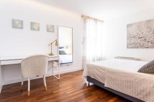 Schlafzimmer mit einem Bett, einem Schreibtisch und einem Spiegel in der Unterkunft Apartments Blue Maris in Split
