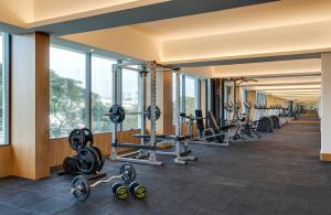 a gym with a row of machines and windows at Greenpark Bengaluru in Bangalore