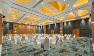 a banquet hall with white tables and chairs at Greenpark Bengaluru in Bangalore