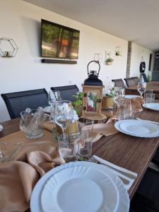 een houten tafel met borden en glazen erop bij Къща за гости Вила Победа 