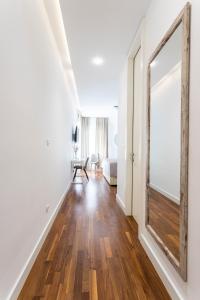 a hallway with a mirror and a living room at Apartments Blue Maris Žnjan in Split