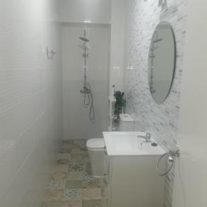 Baño blanco con lavabo y aseo en Apartamentos Sanlucar Beach 1 en Sanlúcar de Barrameda