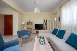a living room with a couch and a table at Sunny Garden Apartments in Pastida