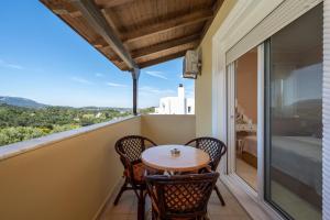 a balcony with a table and chairs and a view at Sunny Garden Apartments in Pastida