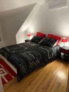 a bedroom with a bed with a black comforter at Le 24’ Chrono in Le Mans