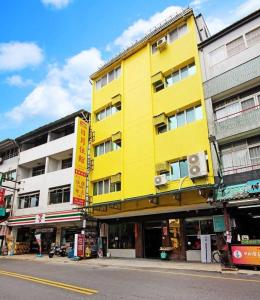 ein gelbes Gebäude an der Straßenseite in der Unterkunft 日月潭 -日月住館-休閒旅館- 水社碼頭 in Yuchi