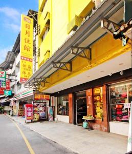 eine Straße mit Geschäften und Schildern an einem Gebäude in der Unterkunft 日月潭 -日月住館-休閒旅館- 水社碼頭 in Yuchi