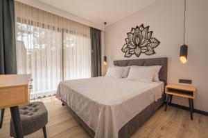 a bedroom with a large bed with a desk and a chair at Sea Valley Lodge in Faralya