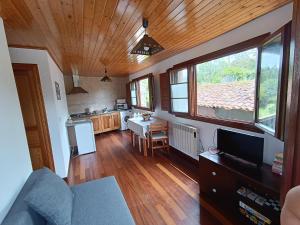 ein Wohnzimmer mit einem Sofa und einem Tisch sowie eine Küche in der Unterkunft Mar Tu Apartamento en Llanes in Llanes