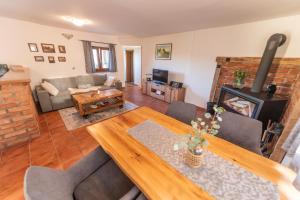 uma sala de estar com uma mesa e uma lareira em Hill Cottage Haloze em Gruškovec