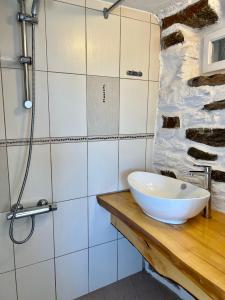 baño con lavabo blanco en una encimera de madera en The Stone Windmill, en Koundouros