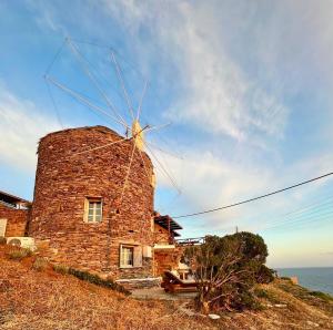 a stone windmill sitting on top of a hill at The Stone Windmill in Koundouros