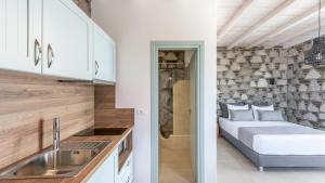 una cucina e una camera con letto e lavandino di Thea Sunset Suites a Mytakas