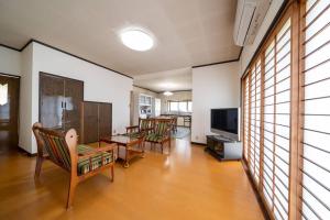 a living room with chairs and a table and a television at Green Hills in Itoigawa