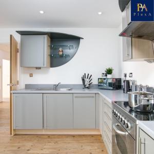 a kitchen with white cabinets and a sink at Peaceful Serviced Apartment - Pluxa The Zen in Birmingham
