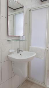 Baño blanco con lavabo y espejo en Chin-Lan B&B, en Zhuangwei