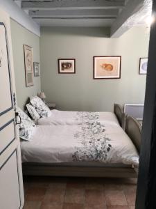 a bedroom with a bed with white sheets at Les Chambres de L'Horloge in Lectoure