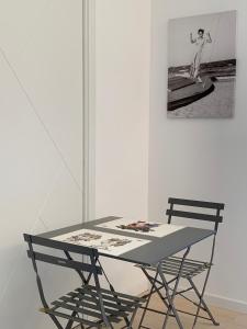 een tafel en een stoel in een kamer met een foto bij Casa Nausica in Acitrezza