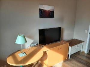 uma sala de estar com uma mesa com uma televisão em FeWo Windsbraut im Landhaus Immenbarg em Rostock