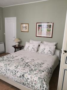 a bedroom with a bed with a floral comforter at Les Chambres de L'Horloge in Lectoure