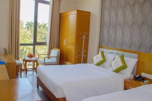 a hotel room with two beds and a window at LUXURY HOTEL in An Bình (1) +4 photos