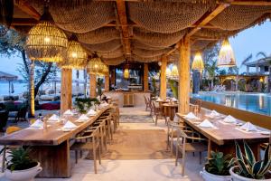 um restaurante com mesas e cadeiras e uma piscina em MAKO Sea & Suites em Pefkohori