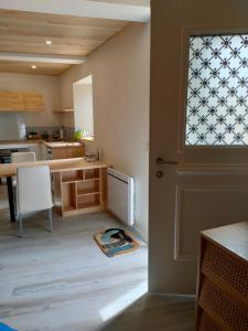 a kitchen with a door and a kitchen with a table at La Lit'Hote in Mirefleurs