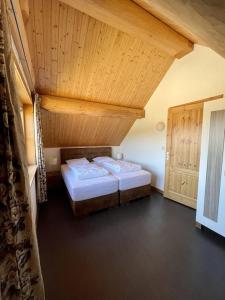 een slaapkamer met twee bedden en een houten plafond bij Unieke houten villa met SAUNA in Twente - 5p in Den Ham