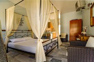 a bedroom with a canopy bed with curtains at Studio Filoxenia in Lipsoi