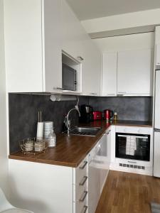 een keuken met witte kasten en een houten aanrecht bij Modern apartment nearby Airport 2 in Vantaa