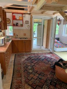 uma cozinha com um tapete no chão e um quarto com uma porta em Bogyó Kert em Nagymaros