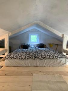 uma cama grande num quarto com uma janela em Bogyó Kert em Nagymaros