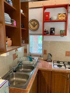 uma cozinha com um lavatório de aço inoxidável e uma janela em Bogyó Kert em Nagymaros