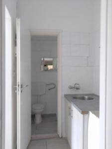 a white bathroom with a sink and a toilet at IOKASTI STUDIOS in Andros