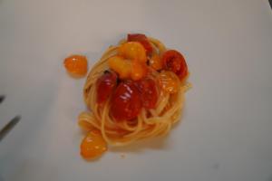 a white plate with pasta and tomatoes on it at Hotel Albatros in Ischia