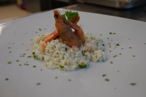a white plate with rice and shrimp on it at Hotel Albatros in Ischia