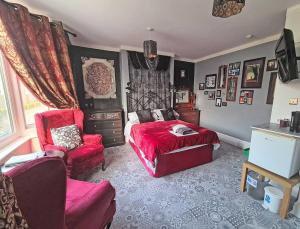 a bedroom with a red bed and a red chair at The Miggi vegan guesthouse in Torquay