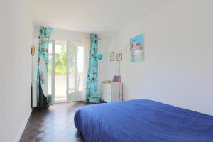 - une chambre avec un lit bleu et une porte coulissante en verre dans l'établissement Espace Lumineux avec Jardin et Garage clos à 15 min de Paris, à Créteil