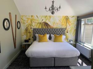 um quarto com uma cama grande e almofadas amarelas em The Old Mill em Lymington